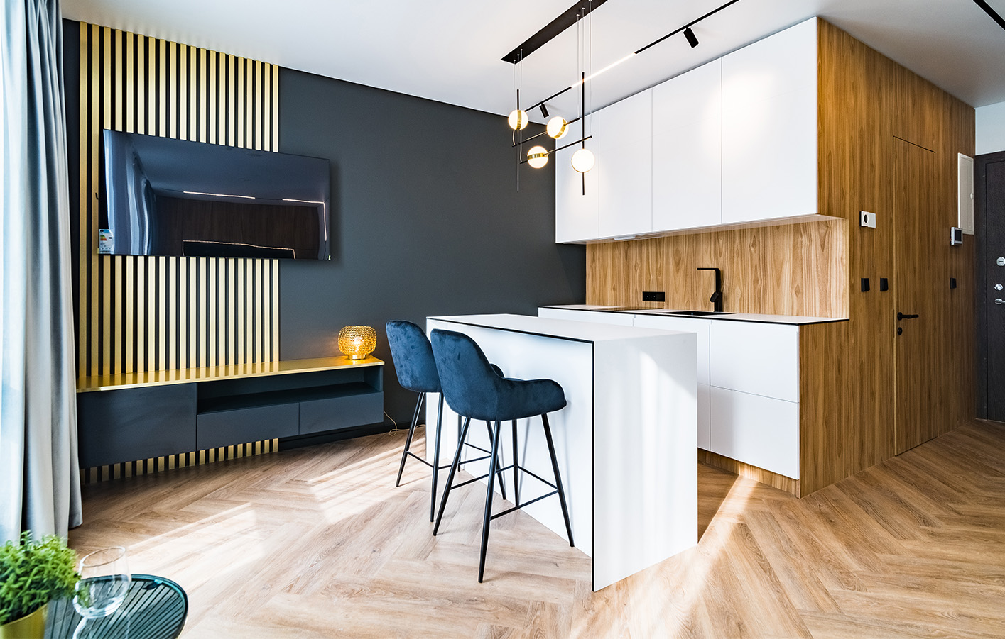 Moderner Wohnbereich mit Bar, weißer Küche und dekorativen Holzpaneelen.